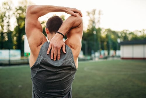 Man doing a gentle back stretching exercise to loosen spinal stiffness