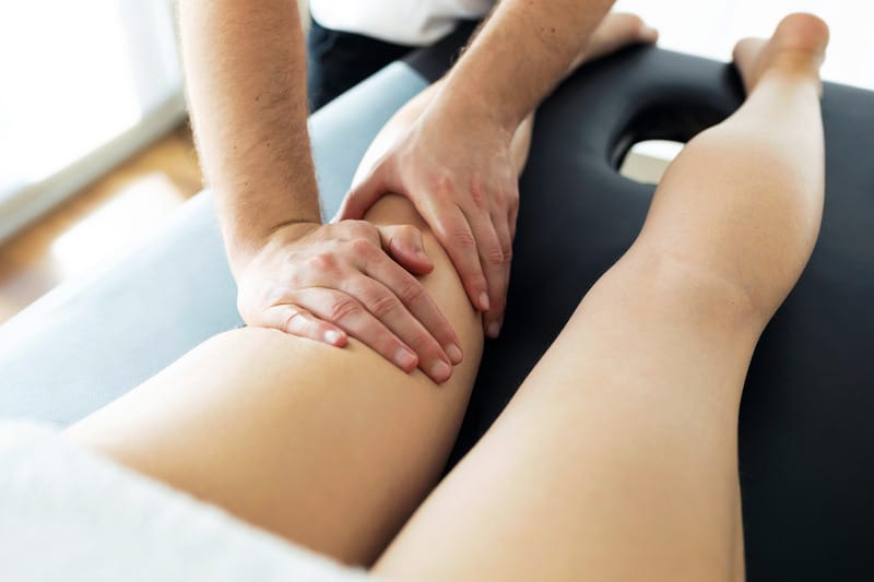 Physiotherapist examining a patient's lower leg and foot for the cause of heel pain