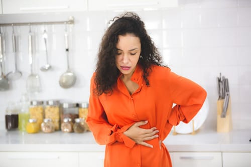 Woman at home thinking about early pregnancy symptoms