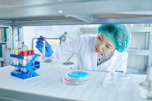 Lab worker handling blood samples for hCG pregnancy hormone testing