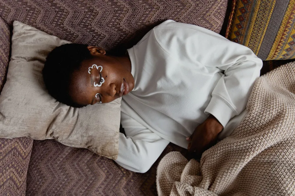 Woman sleeping peacefully in dark bedroom supporting overnight skin repair and anti-aging