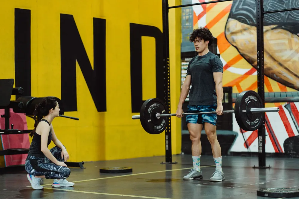 Person performing a deadlift with incorrect form causing lower back strain