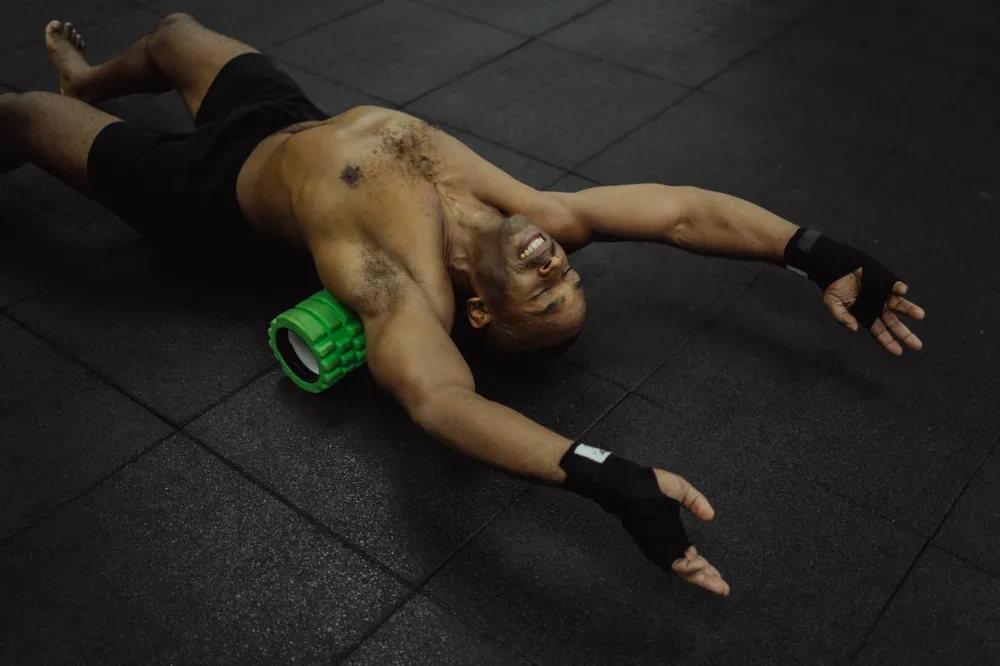 Woman using a foam roller on her upper back for post-workout recovery