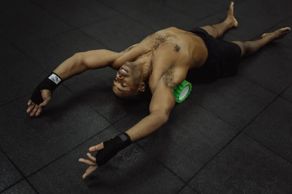 Man doing a lower back stretch on a mat to relieve post-gym back pain