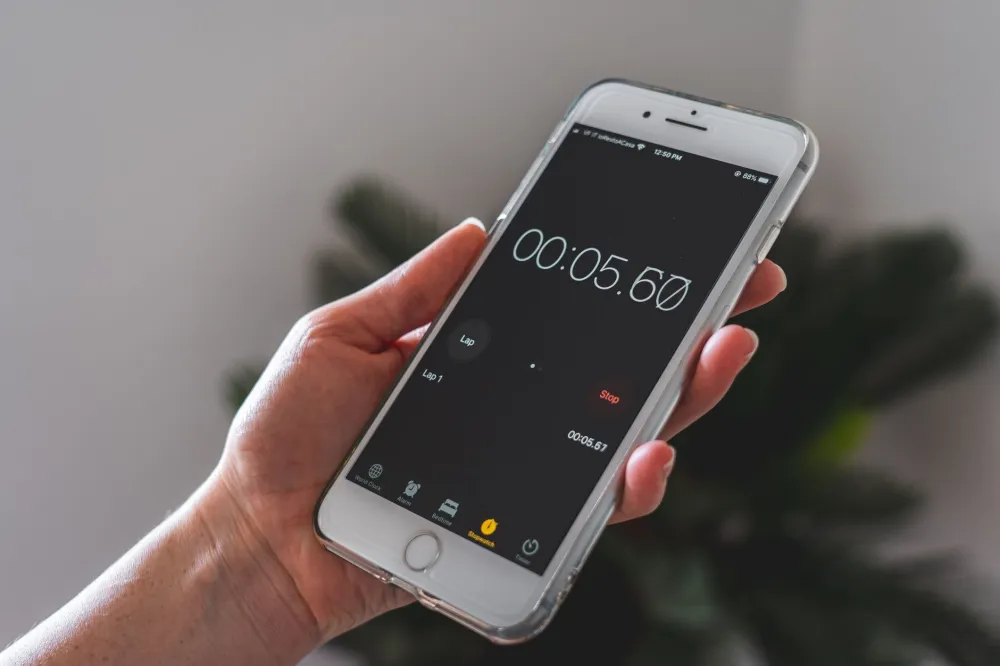 Smartphone timer set for five minutes on a wooden table for a meditation session