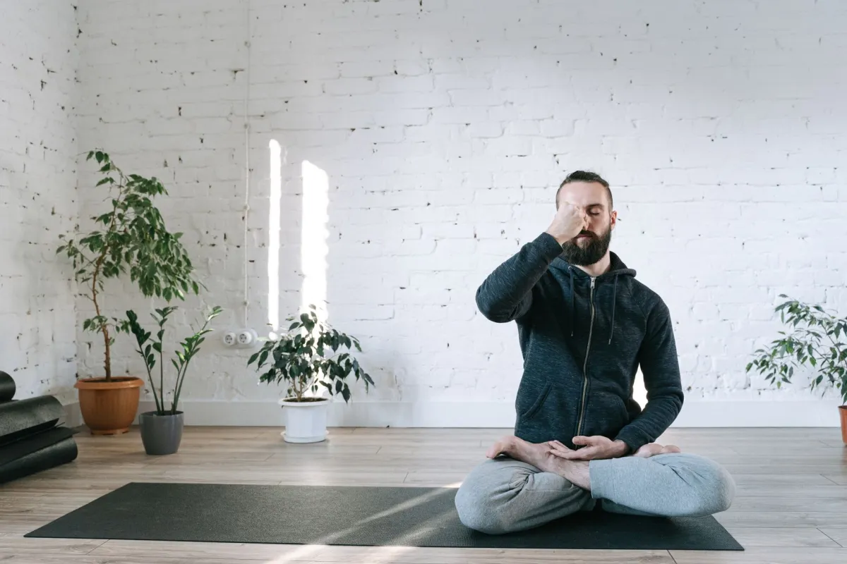 Person sitting quietly practicing beginner meditation in a bright living room