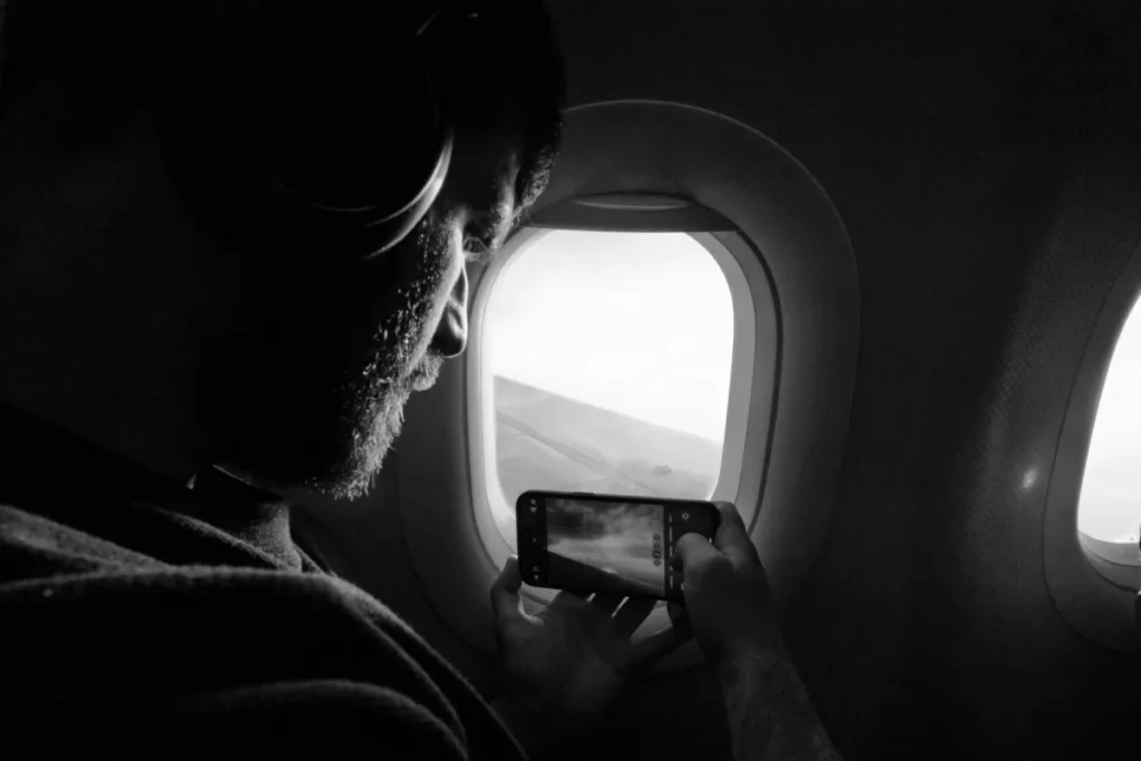 Passenger looking out airplane window experiencing blocked ears on flight