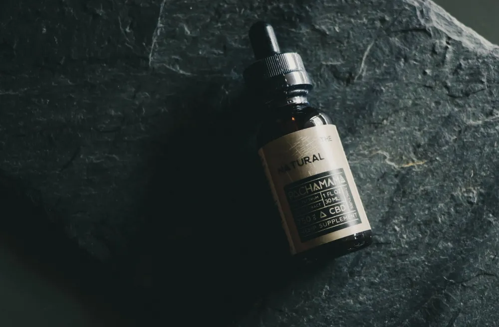 CBD & THC Oil for Dementia Agitation: What Research Says 3 Small glass dropper bottle of CBD oil on wooden surface