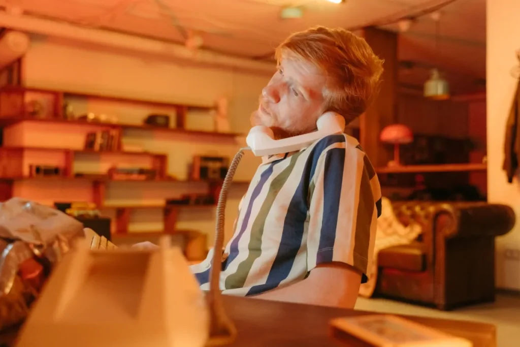 Desk Posture and Back Pain From Sitting All Day: What Works 25 Person slouching at office desk experiencing back pain from poor sitting posture