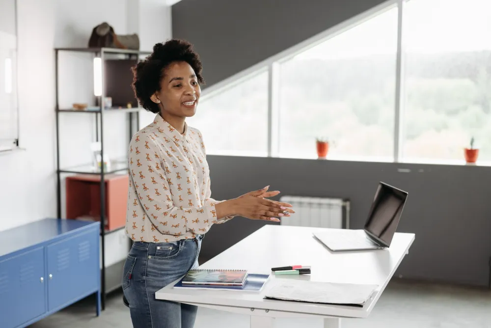 Desk Posture and Back Pain From Sitting All Day: What Works 3 Worker alternating between sitting and standing at height-adjustable desk to reduce back pain