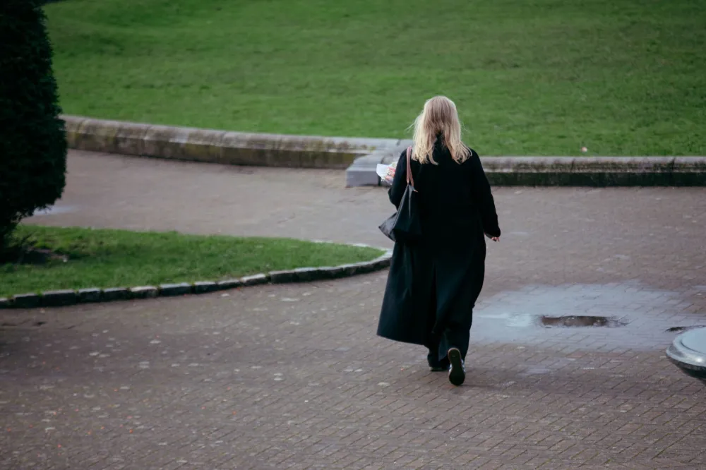 Woman walking briskly in a park as part of a heart-healthy daily routine