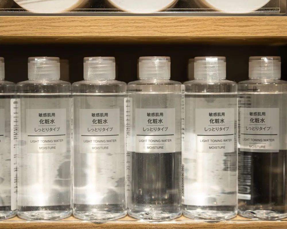 Row of winter skincare products including cleanser serum and thick moisturizer on bathroom shelf