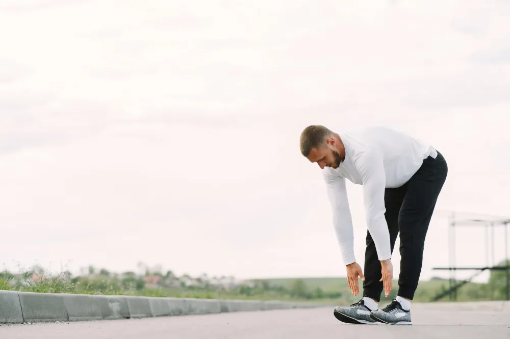 Middle-aged man stretching his hamstrings during a morning movement routine