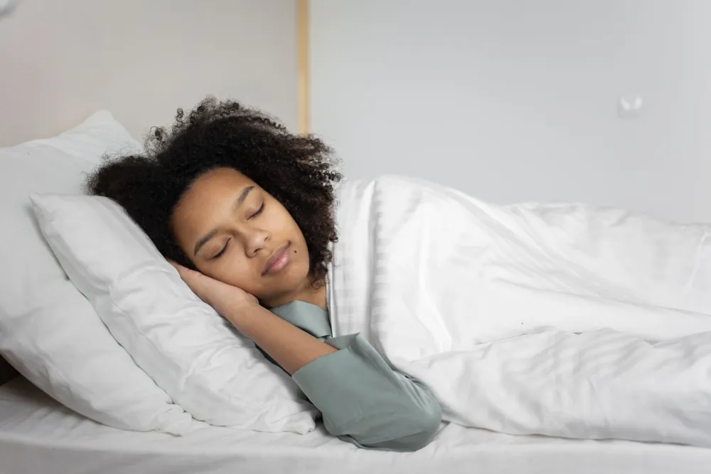 Woman sleeping restfully in bedroom to support immune function during flu season