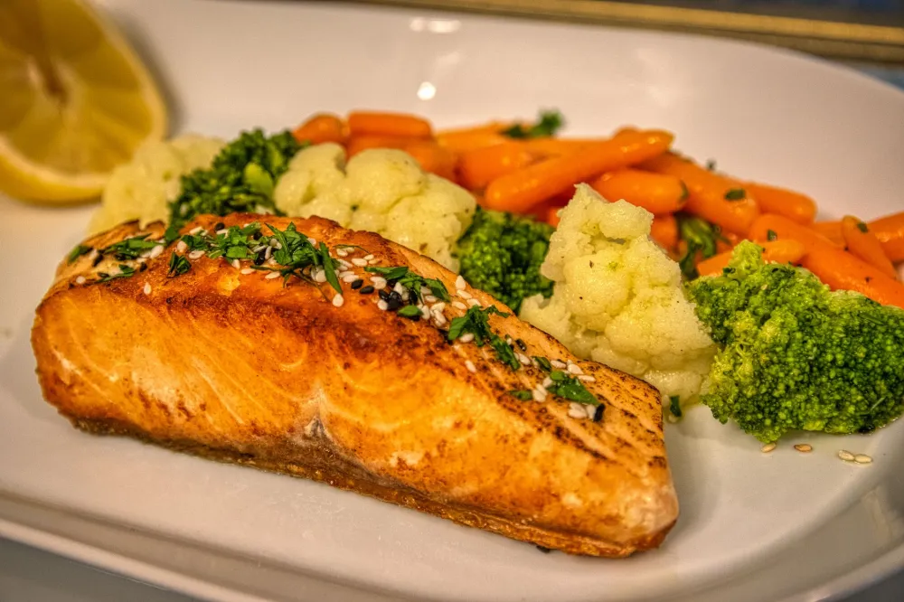 Grilled salmon with roasted vegetables on a plate for ketogenic diet plan