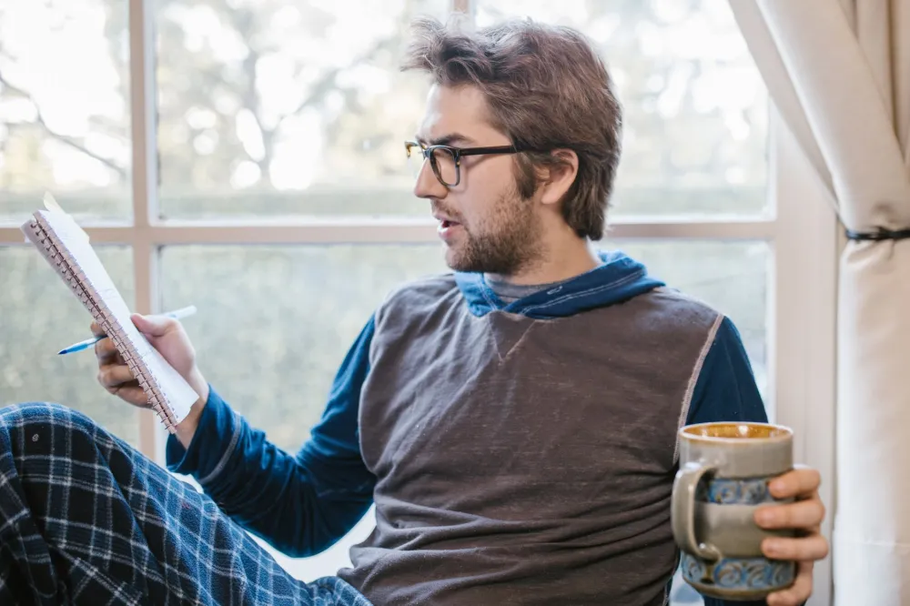 Person journaling at a table tracking mood changes during GLP-1 therapy