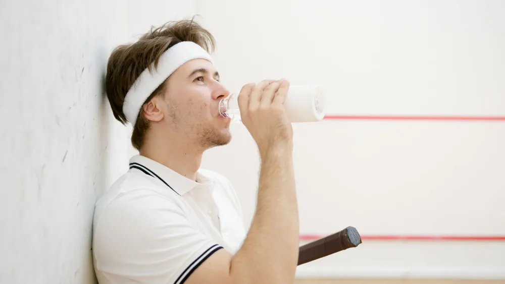 Athlete drinking water during outdoor exercise to replace fluid lost through sweat