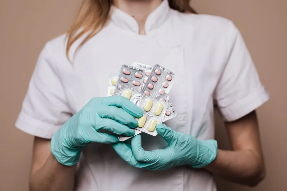 Pharmacist handing medication bag to customer discussing GLP-1 drug savings options