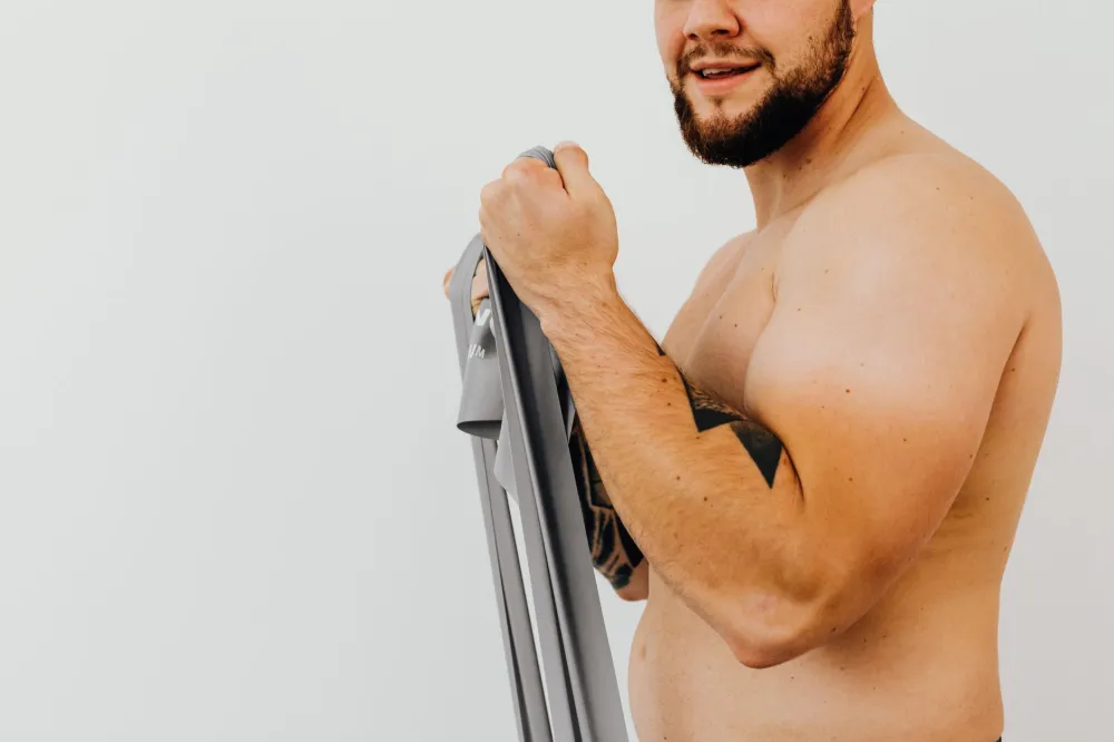 Man doing resistance band exercise at home to preserve muscle during GLP-1 weight loss