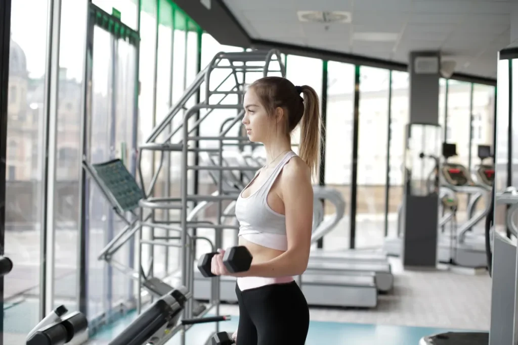 Woman lifting dumbbells at gym to prevent muscle loss on GLP-1 medication