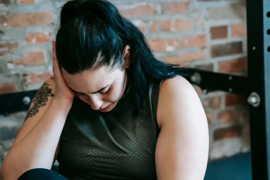 Metabolism Myths Keeping You Stuck: What Actually Works 43 Woman looking frustrated standing on bathroom scale during weight loss attempt