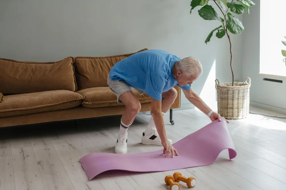 Person doing a gentle yoga stretch on a living room floor in the morning
