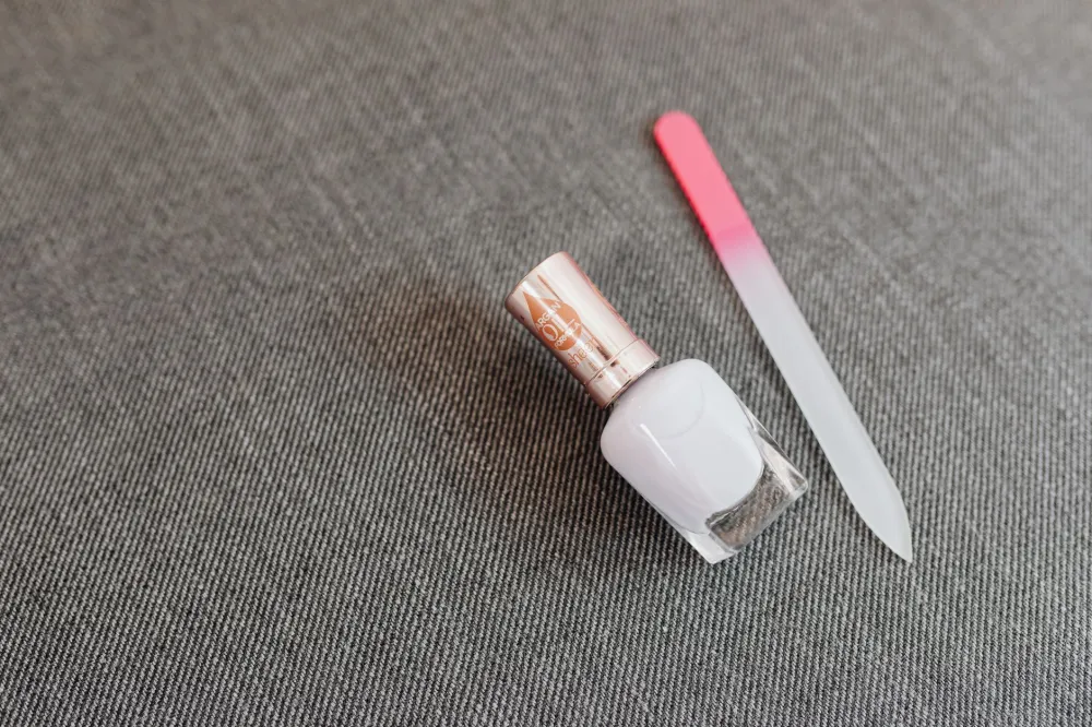 Nail care tools including file, cuticle oil, and moisturizer arranged on a clean surface