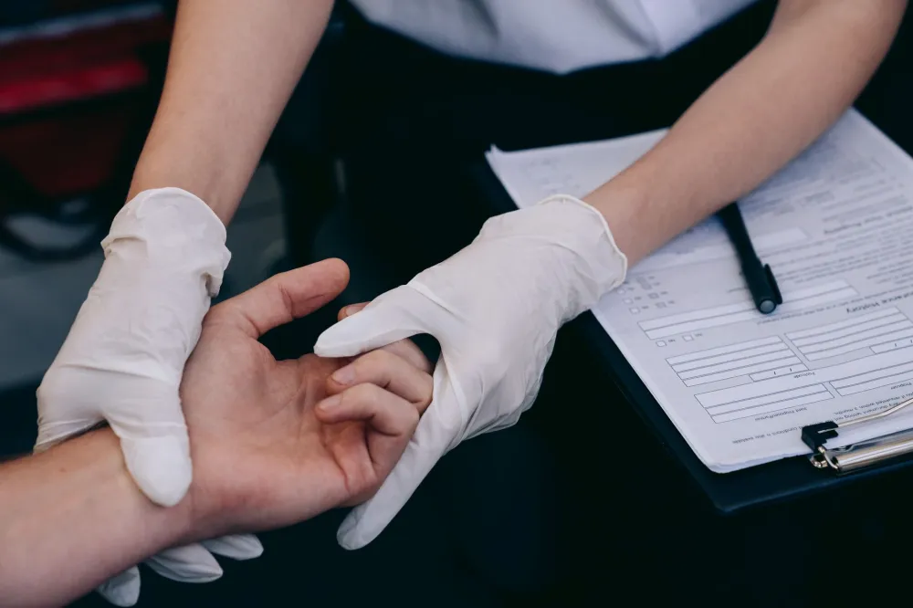Doctor examining patient fingernails for signs of underlying health conditions during checkup