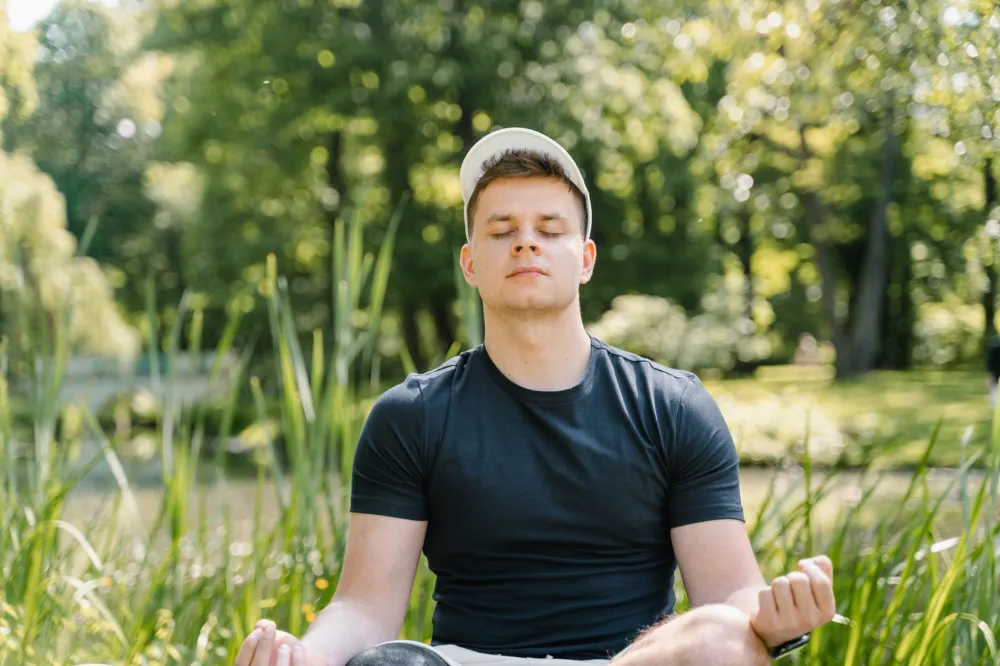 Oregon's Psilocybin Program: What the Research Shows 2 Person meditating outdoors in nature supporting mental wellness and stress relief
