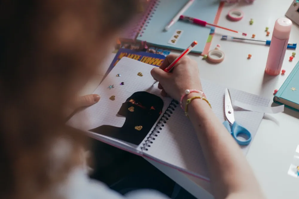 Oregon's Psilocybin Program: What the Research Shows 3 Woman journaling at desk as part of a daily mental health and stress management routine