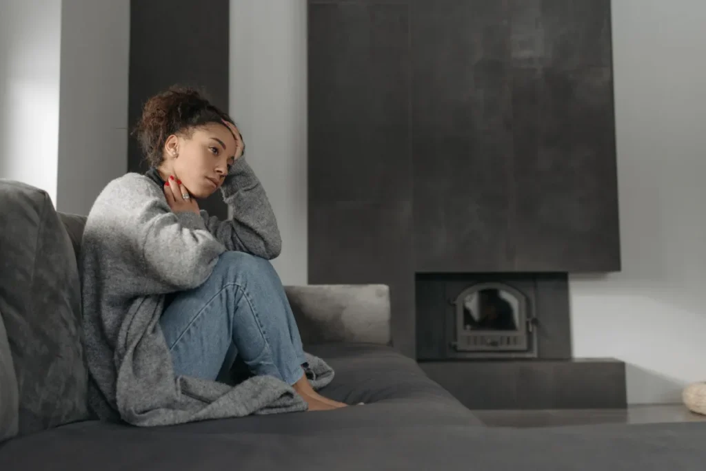 Woman touching her throat indoors experiencing post-nasal drip discomfort