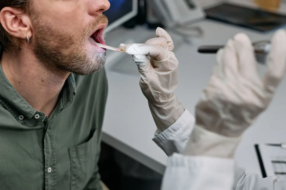 Post-Nasal Drip & Constant Throat Clearing: What Actually Works 4 Doctor examining a patient's throat and sinuses during an ENT health consultation