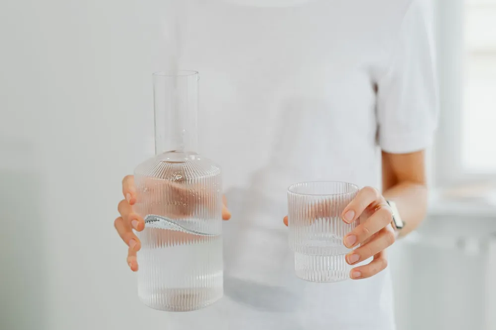 Post-Nasal Drip & Constant Throat Clearing: What Actually Works 5 Person drinking a glass of water in the morning to thin mucus and reduce throat clearing