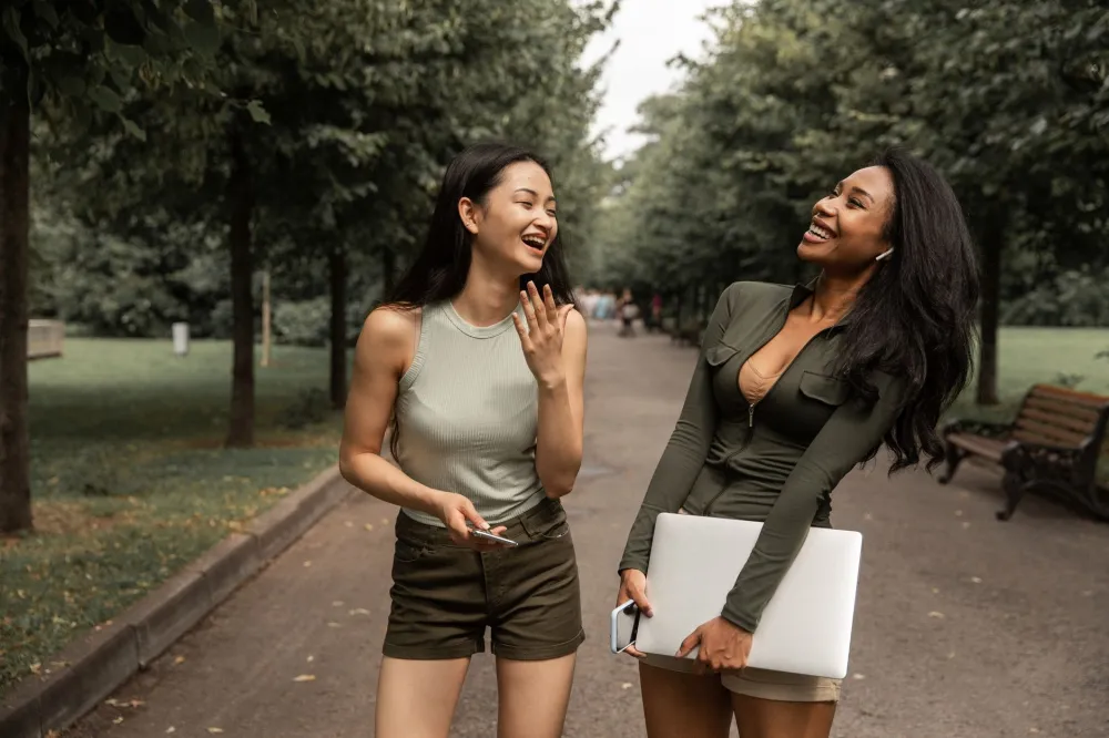 Group of friends laughing outdoors showing social connection benefits for healthy aging