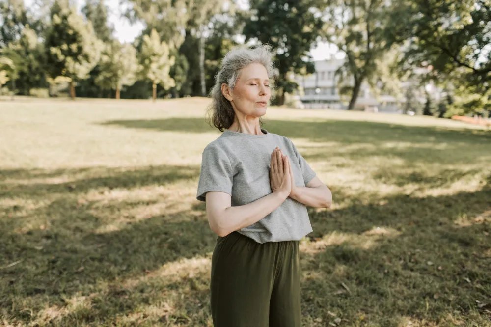 Woman practicing deep breathing outdoors to reduce stress and support gut health