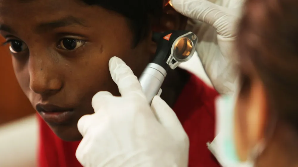 Audiologist conducting a hearing test on a patient in a soundproof clinic booth