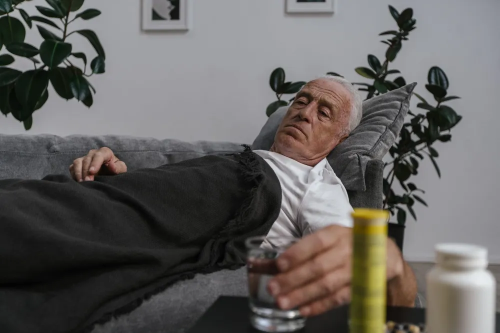 Man lying on couch resting with lower back pain at home