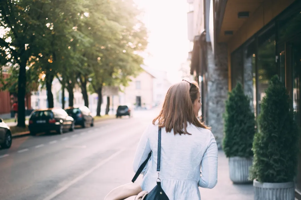 Woman taking a gentle morning walk outdoors to relieve back pain