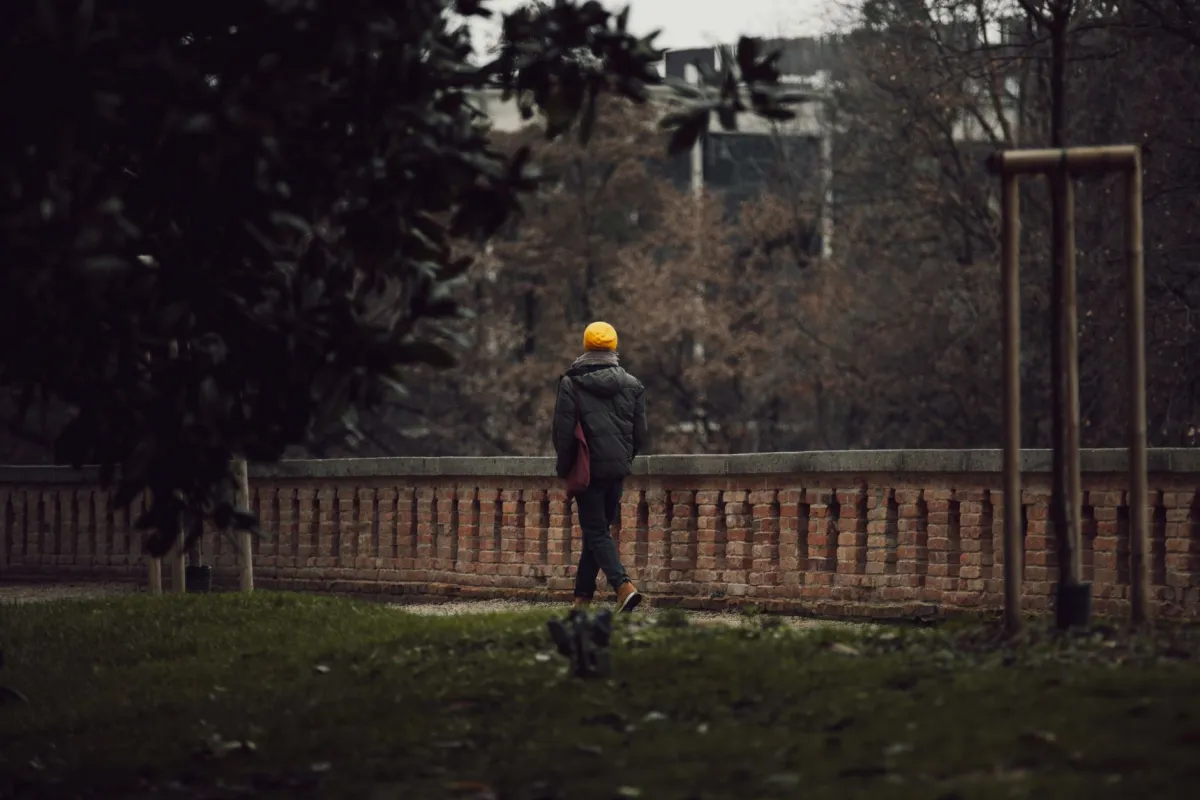 Person walking on a park path as gentle exercise for lower back pain relief