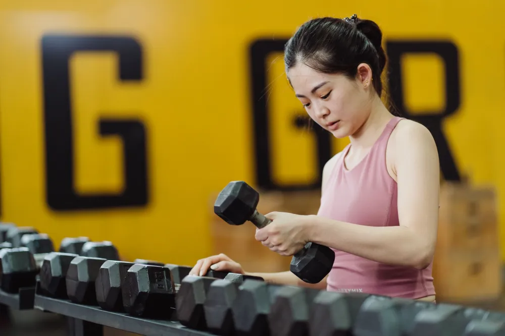 Woman doing strength training exercises to boost metabolism during weight loss plateau