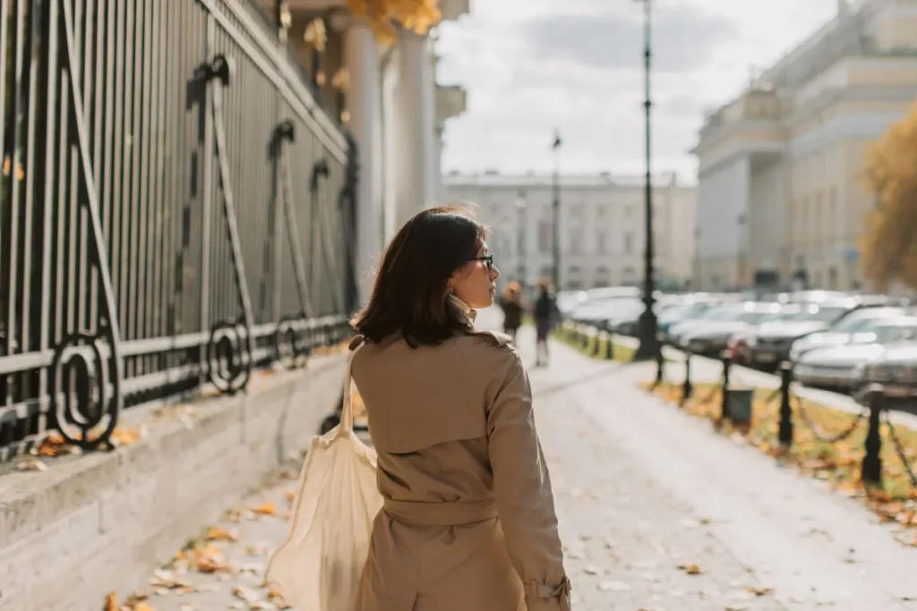 Woman walking briskly on a city sidewalk tracking her daily step count