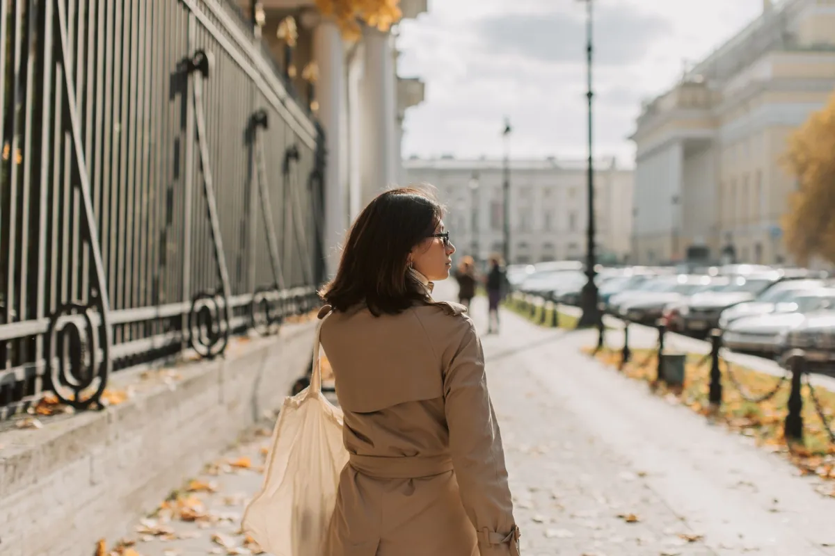 Woman walking briskly on a city sidewalk tracking her daily step count
