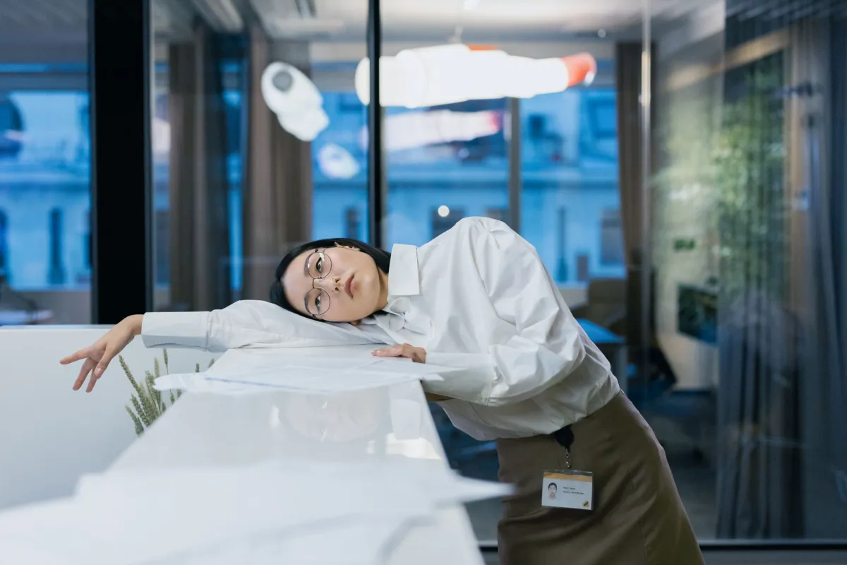 Woman looking fatigued at her desk during an afternoon energy crash