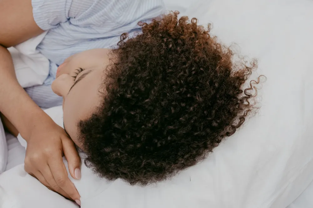 Woman sleeping on her side with a pillow between her knees for back pain relief