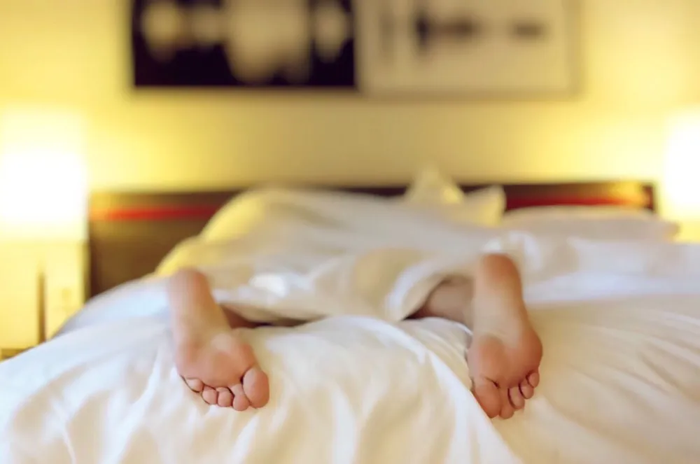 Man sleeping on his stomach, a position that strains the lower back and spine