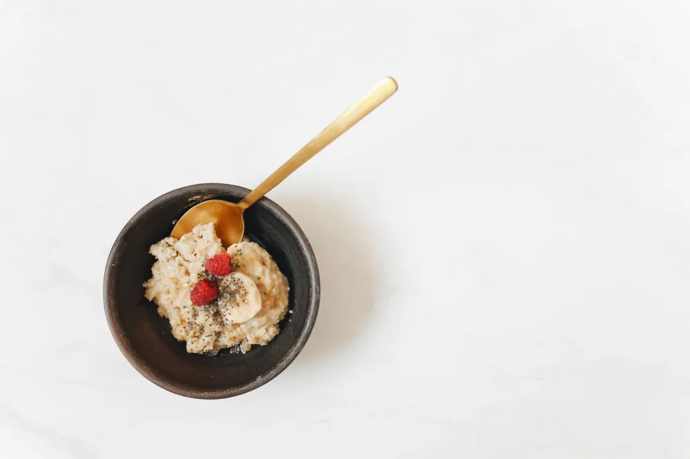 Bowl of oatmeal topped with fresh berries and nuts for a low-sugar breakfast