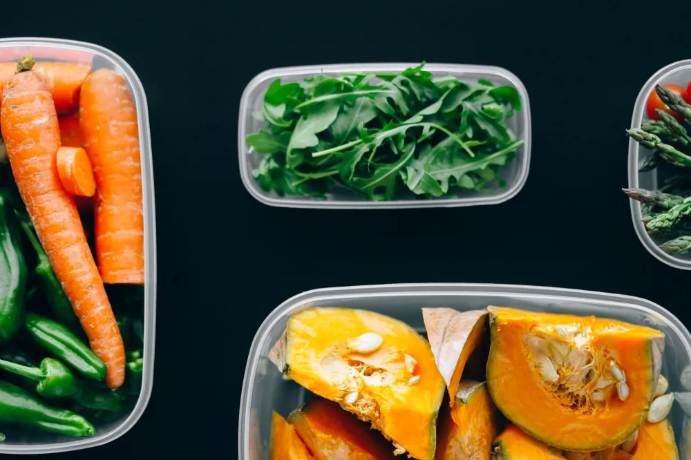 Colorful meal prep containers with vegetables and protein for a low-sugar diet plan