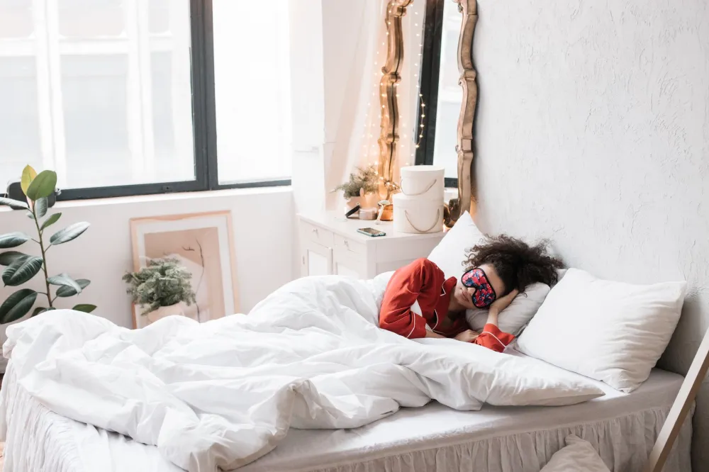 Person sleeping soundly in a dark bedroom to support a healthy immune system