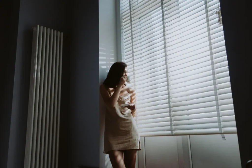 Woman practicing daily habits to support immunity by drinking water in morning sunlight