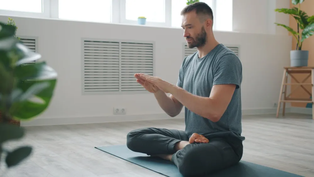 Person practicing calm breathing at home to lower stress and support immune health